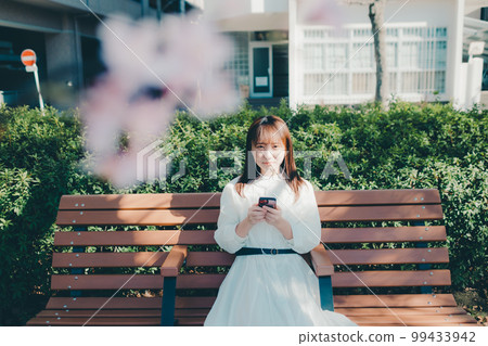 Photo of a young woman listening to music in the park 99433942