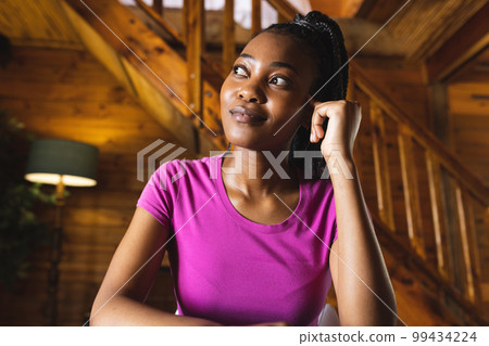 Happy african american woman spending time in log cabin and having video call 99434224