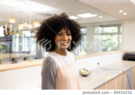 Happy biracial businesswoman looking at camera in office 99434258