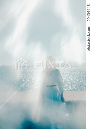 Photo of a young woman standing on the beach Photo of a young woman standing on the beach 99434448