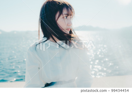 一位年輕女子站在沙灘上的照片 一位年輕女子站在沙灘上的照片 99434454