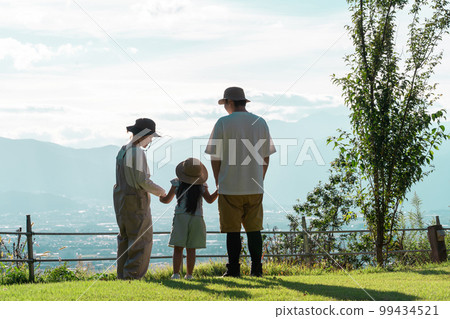 Parents and children (playing) who are impressed by the mountains, mountains, sky, and superb view at the campsite 99434521