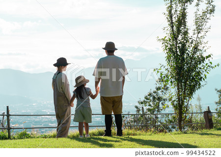 Parents and children (playing) who are impressed by the mountains, mountains, sky, and superb view at the campsite 99434522