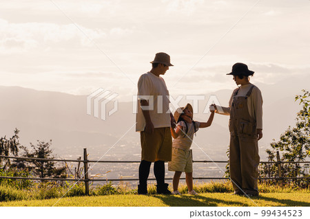 Parents and children (playing) who are impressed by watching the sunset / sunset at the campsite 99434523