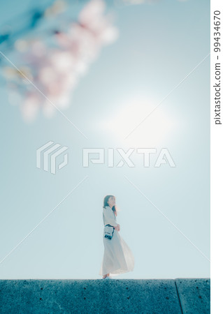 Photo of a young woman standing on the beach Photo of a young woman standing on the beach 99434670