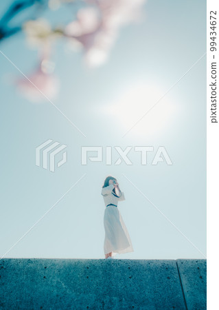 Photo of a young woman standing on the beach Photo of a young woman standing on the beach 99434672