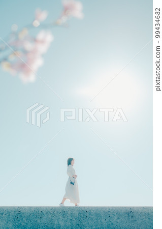 Photo of a young woman standing on the beach Photo of a young woman standing on the beach 99434682