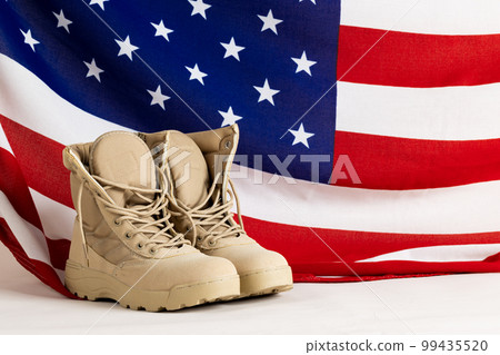 Military boots over flag of usa on white background, with copy space 99435520
