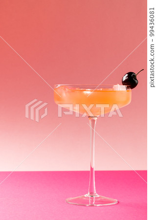 Vertical image of glass with drink and fruits over pink background Vertical image of glass with drink and fruits over pink background 99436081