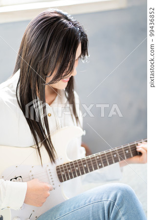 Young woman portrait (electric guitar) 99436852