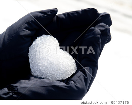 一顆雪做的心放在戴著手套的手上。 一顆雪做的心放在戴著手套的手上。 99437176