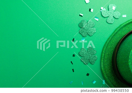 Image of green hat, clover and copy space on green background Image of green hat, clover and copy space on green background 99438550