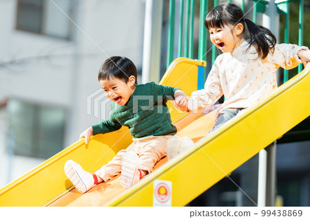 孩子們手牽著手滑下滑梯 99438869
