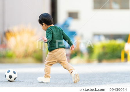 3 year old boy chasing a soccer ball 99439034