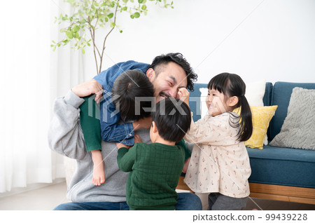 Papas who are mobbed by children on holidays Raising children is very difficult 99439228