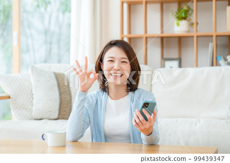 一位中年婦女拿著智能手機 OK 99439347