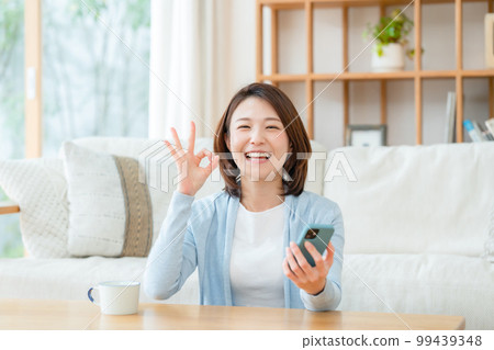 一位中年婦女拿著智能手機 OK 99439348