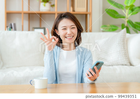 一位中年婦女拿著智能手機 OK 99439351