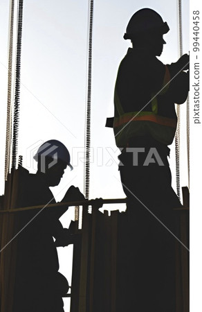 silhouette of worker at the construction site at sunset silhouette of worker at the construction site at sunset 99440458
