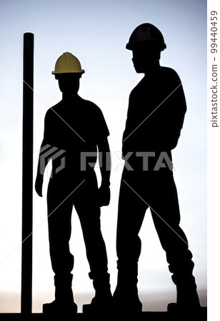 silhouette of worker at the construction site at sunset 99440459