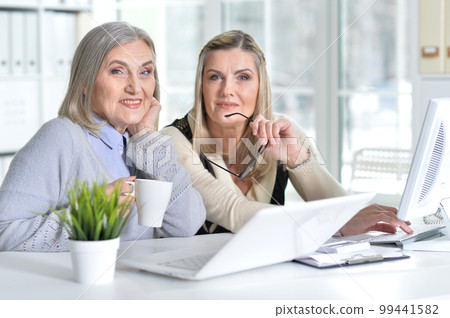 two excited mature women working in office 99441582