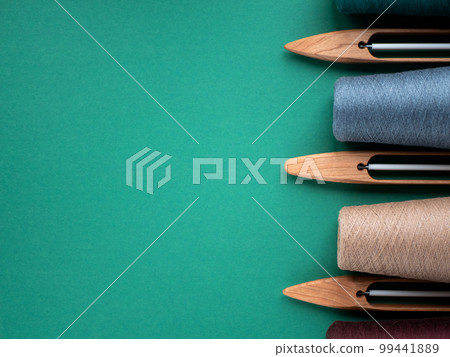 Wooden boat shuttles for handloom and cones with yarn, copy space. Concept of weaving tools 99441889