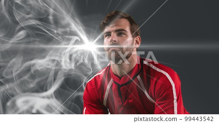 Caucasian male athlete against smoke effect and light spot on grey background 99443542