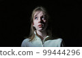 The girl covers her face with her hands in fear 99444296