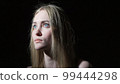 The young woman shows emotions of fear on her face 99444298