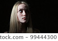The young woman shows emotions of fear on her face 99444300