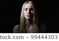 The young woman shows emotions of fear on her face 99444303