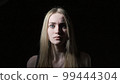 The young woman shows emotions of fear on her face 99444304