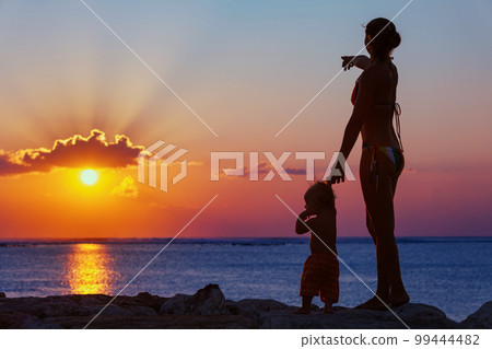 Mother with son look at sunset sun on the beach Mother with son look at sunset sun on the beach 99444482