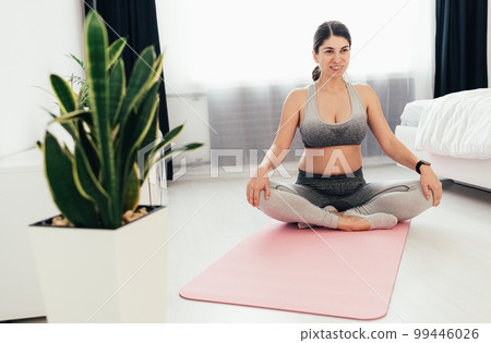 Time for yoga. Attractive and healthy young woman doing exercises while resting at home Time for yoga. Attractive and healthy young woman doing exercises while resting at home 99446026