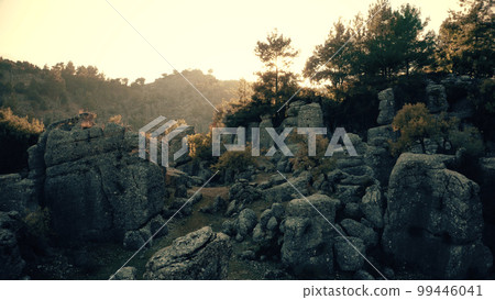 Sun shining over majestic rock formations. Green valley with incredible gray stones. Geological landscape. 99446041