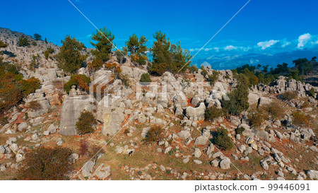 Scenic mountains landscape with rock formations and green trees on the background of blue sky. Panoramic view from drone. 99446091