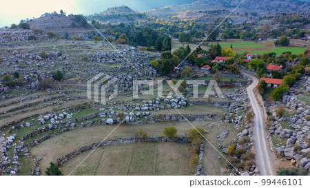 Small village in a rocky mountain valley. Beautiful landscape of valley with village and rural road in the morning. Small village in a rocky mountain valley. Beautiful landscape of valley with village and rural road in the morning. 99446101