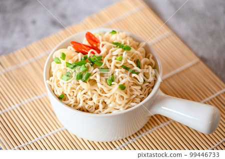 noodles bowl with vegetable spring onion and chili on wooden table food , instant noodles cooking tasty eating with bowl - noodle soup 99446733