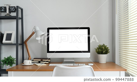 Modern home office interior with blank computer screen on wooden desk. Empty screen for your advertising and creative design 99447888