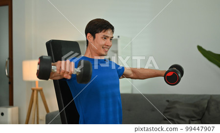 Image of motivated asian man exercising with dumbbells at home. Fitness, weightlifting and bodybuilding concept Image of motivated asian man exercising with dumbbells at home. Fitness, weightlifting and bodybuilding concept 99447907