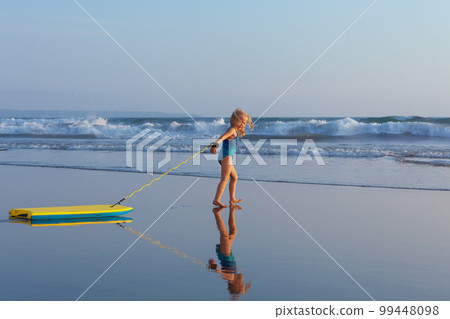 Young surfer girl with bodyboard has fun on sea beach Young surfer girl with bodyboard has fun on sea beach 99448098