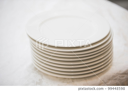 A stack of white plates on the table 99448598