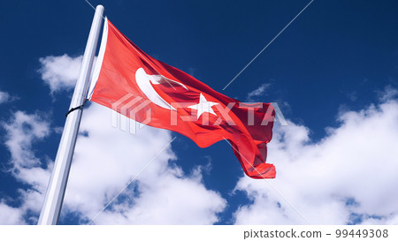 The Turkish flag is being raised. A close-up. A blue sky with clouds in the background. The national flag of Turkey. The Turkish flag is being raised. A close-up. A blue sky with clouds in the background. The national flag of Turkey. 99449308