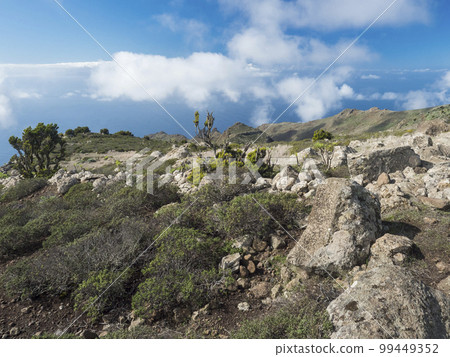 Rocky platau, hills sharp rock formation, hills and cliffs seen seen from hiking trail at Park rural de teno, Tenerife, Canary Islands, Spain. sunny winter day, blue sky 99449352