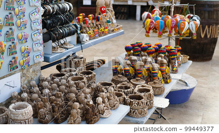 Small multicoloured toy balloons on the counter of a street shop. A pile of souvenirs for tourists on holiday in Cappadocia. Close up. Selective focus. Small multicoloured toy balloons on the counter of a street shop. A pile of souvenirs for tourists on holiday in Cappadocia. Close up. Selective focus. 99449377