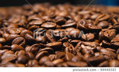 Close-up of brown roasted coffee beans. Cappuccino, espresso, caffe latte, Americano. The concept of a cafe. Coffee as a way of life for the modern man. Close-up of brown roasted coffee beans. Cappuccino, espresso, caffe latte, Americano. The concept of a cafe. Coffee as a way of life for the modern man. 99449385
