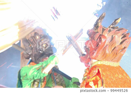 A red demon and a green demon clash with torches at the demon chasing ceremony. A red demon and a green demon clash with torches at the demon chasing ceremony. 99449526
