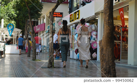People walk along a popular pedestrian shopping street in the centre of Antalya. Antalya's old town is a popular destination for tourists 99450062