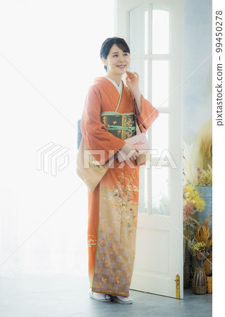 A woman in an orange visiting dress A woman in an orange visiting dress 99450278