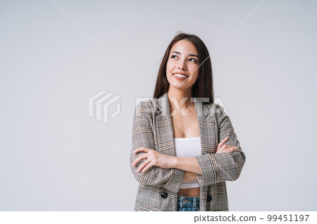Young happy asian woman with long hair in suit on grey background Young happy asian woman with long hair in suit on grey background 99451197